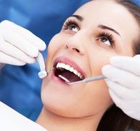 Woman having teeth examined at dentists